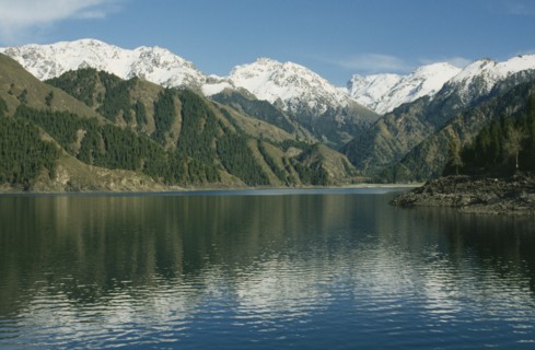 CHINA, Xinjiang , Lake Tianchi, View over the lake toward snow capped mountain peaks
