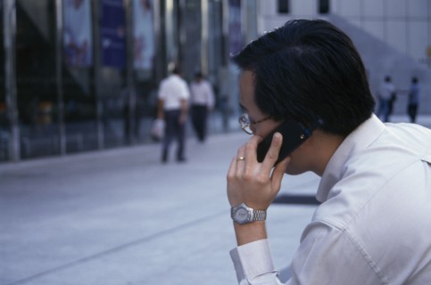 SINGAPORE, Raffles Place, Profile of city worker on mobile phone in the street in the financial