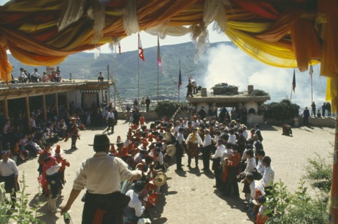 CHINA , Qinghai, Tongren , Dancers at Tibetan festival seen through canopy