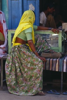 INDIA, Rajasthan, Devgarh , "Woman in rose patterned sari and yellow head covering wearing ankle