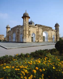 BANGLADESH, Dhaka, Lalbagh Fort.  Exterior facade with paving and orange flowers in the foreground.