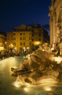 ITALY, Lazio , Rome, Trevi Fountain at night with people siting around the fountain