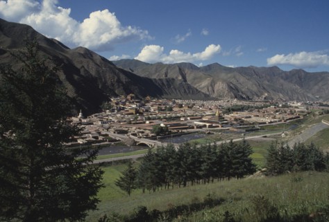 CHINA, Gansu, Xiahe, General view over Labrang Monastery from a distance with surrounding hills