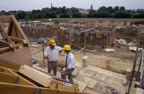 CONSTRUCTION,  , Surveyors, Surveyor wearing safety helmet talking to foreman on building