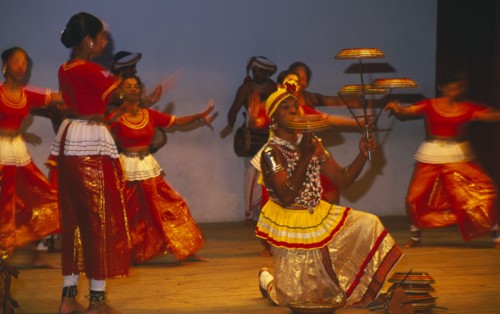 SRI LANKA, Kandy Dancers, Traditional dancers and man spinning plates on poles and fingers on stage