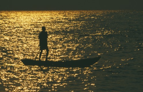 TANZANIA, Lake Tanganyika , Mokoro canoe raft paddler on lake at sunset