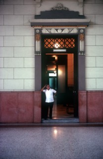 CUBA, Havana , University interior with man standing in hallway entrance