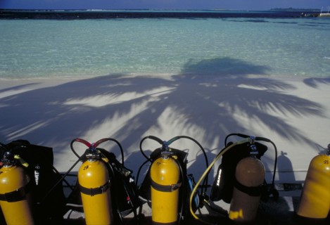 MALDIVES, Nika Island, Looking out to sea with scuba diving tanks on the beach in the shadow of