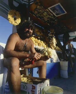 GREECE, Dodecanese Islands, Kos, Kardamina fisherman cleaning sponges at his natural sea products