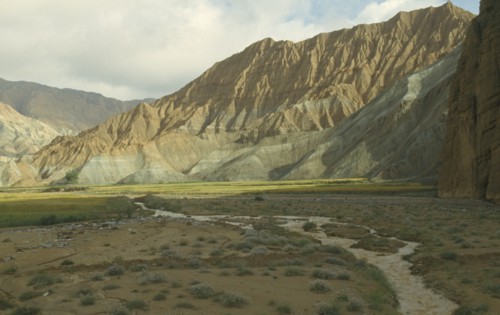 CHINA, Qinghai  , Yellow River , Eroded rocks above wheat fieldin  high altitude remote valley