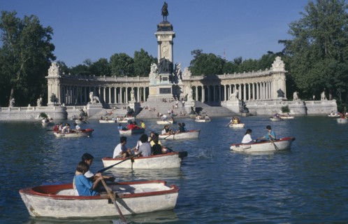 SPAIN, Madrid , El Retiro Park. View over the busy boating lake toward column with equestrian