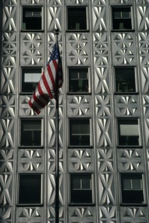 USA, New York, Manhattan, American flag flying in front of building with aluminium facade