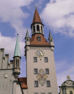 GERMANY, Bavaria, Munich, Clock tower with ornate clock and coat of arms with parts of the rooves