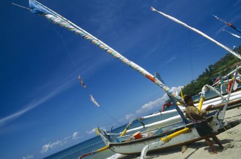 INDONESIA, Lombok, Senggigi, Outrigger sailboats on the beach with fisherman
