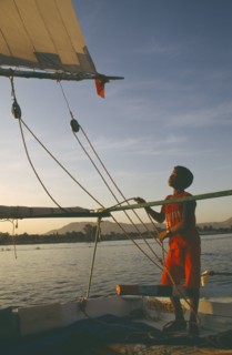 EGYPT,  , Transport, Felucca on the River Nile in the evening with young boy adjusting rigging