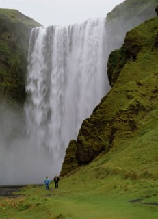 ICELAND, Skogafoss Waterfall, Cascading waterfall 60 metres or 200 feet high.  Two people walking
