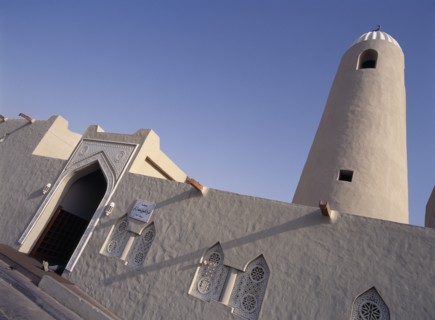 QATAR, Doha, Angled view of Small Mosque in the old souk area showing front entrance and minaret.