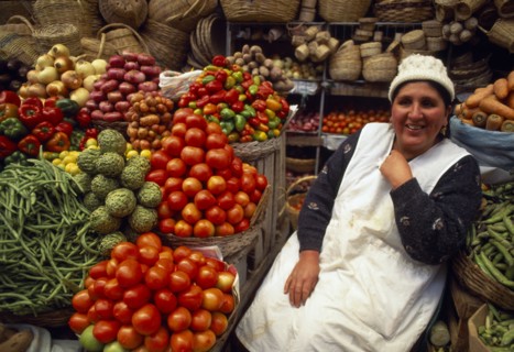 BOLIVIA,  , Sucre, Fruit and vegetable stall and smiling woman vendor.