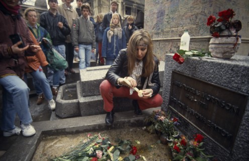 FRANCE, Ile de France, Paris, Pere Lachaise Cemetery. Visitors surrounding Jim Morrison grave with