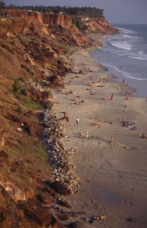INDIA, Kerala, Varkala, "Beach sheltered by steep, eroded cliffs with sunbathers on the sand and