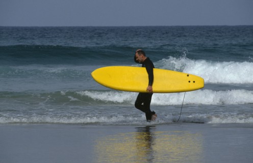 ENGLAND, Cornwall, Newquay, Surfer on Fistral Beach