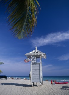 USA, Florida , Fort Lauderdale, Lifeguard hut on sandy beach with American flag flying