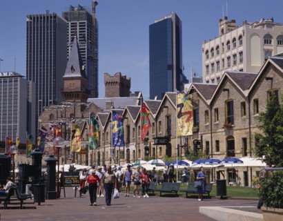 AUSTRALIA, New South Wales, Sydney, The Rocks harbourside area with people walking past restaurants