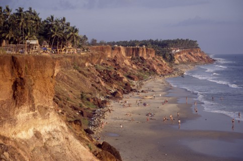 INDIA, Kerala, Varkala , "Coastline and narrow sandy cove with sunbathers sheltered by steep,