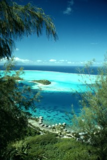 PACIFIC ISLANDS, French Polynesia, Bora Bora, Aerial view over lagoon with cresent of Hotel huts