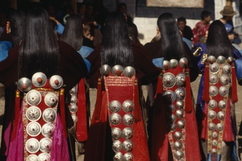CHINA, Guizhou, Tongren, Tibetan dancers at a festival wearing traditional costumes with silver