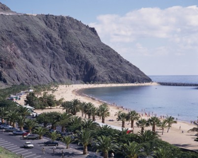 SPAIN, Canary Islands, Tenerife, Las Teresitas. Long sandy bay beneath black cliffs and palm lined