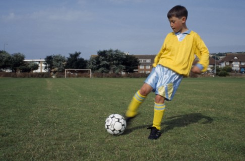 SPORT, Ball Games, Soccer, Young boy kicking football.