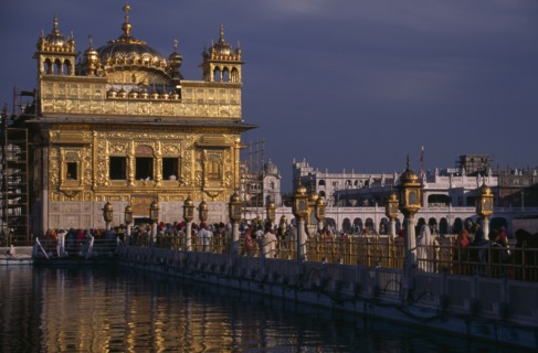 INDIA, Punjab, Amritsar, The Sikh Golden Temple with people on the walkway across the water