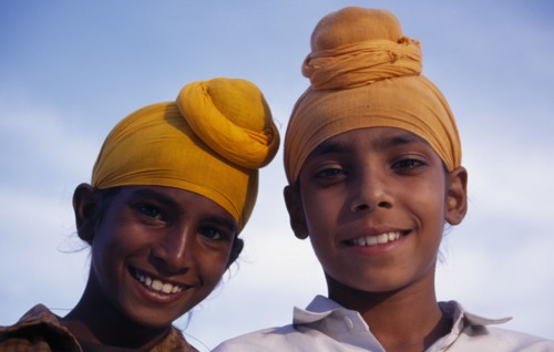 INDIA, Punjab, Amritsar, "Two Sikh boys.  Head and shoulders portrait, smiling."