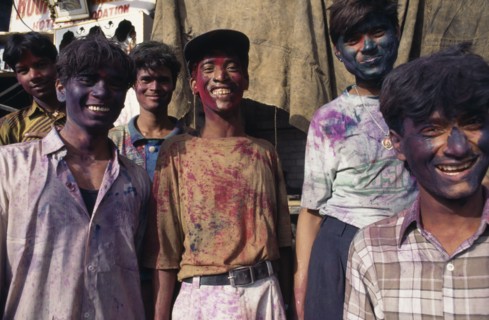 INDIA, Delhi , Group of young men with their faces covered with coloured powder paint dyes during