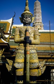 THAILAND, Bangkok, Wat Phra Kaew, Or Grand Palace. Elaborate statue with tower behind