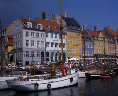 DENMARK, Zealand, Copenhagen, Nyhavn Harbour. Traditional waterfront buildings with crowds of