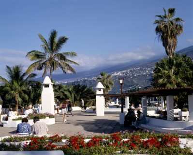 SPAIN, Canary Islands, Tenerife, "Promenade,whitewashed walls,wooden sunshades,flowers,people,hills