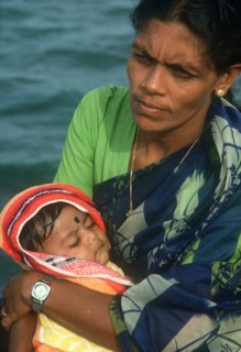 SRI LANKA, People, Woman holding baby in her arms. Traditionally dressed and wearing modern wrist