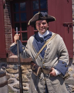 CANADA, Nova Scotia, Cape Breton Island, Fortress of Louisbourg with a smiling costumed soldier