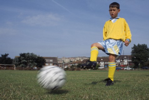 SPORT, Ball, Soccer, Young boy kicking football.