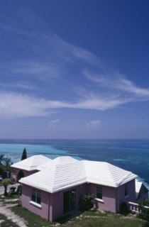 BERMUDA, Somerset, Clifftop house. Purple painted exterior with white roof and view out to sea.