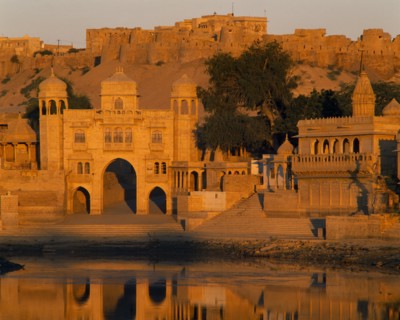 INDIA, Rajasthan, Jaisalmer, Gadi Sagar Tank  with buildings the Fort in the background