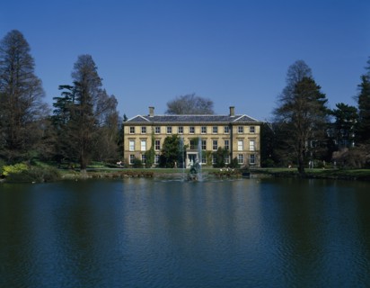 ENGLAND, London, Kew Gardens, View over lake towards large house and fountains with visitors