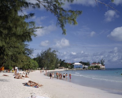 BARBADOS, Christchurch, "Rockley Beach, white sand, sunbathers, houses on headland, trees "