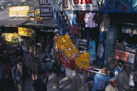 INDIA, Himachal Pradesh, Kulu, Figures of temple gods garlanded with flowers being carried through