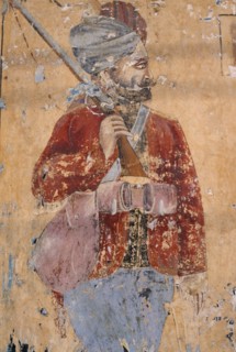 INDIA, Rajasthan , Shekhawati Region, Lachhmangarh. Old mural of a man holding a rifle