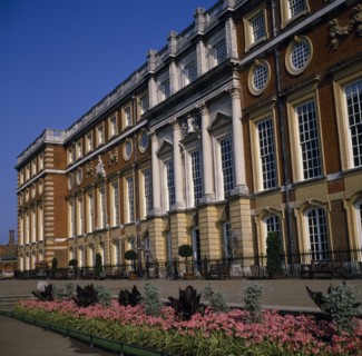 ENGLAND, London, Hampton Court Palace.  Angled view of exterior over     flower borders