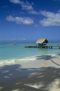 WEST INDIES, Tobago, Pigeon Point, View across shoreline toward wooden boat jetty with hut