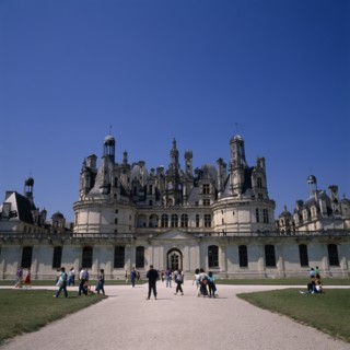 FRANCE, Loire Valley, Loir et Cher, Chambord Chateau. Tourists on gravelled entrance between green